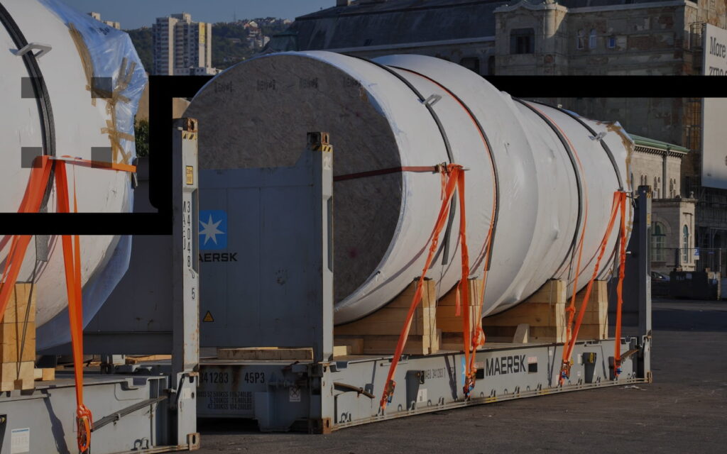 Large industrial cylinders lashed on flat rack containers for transport